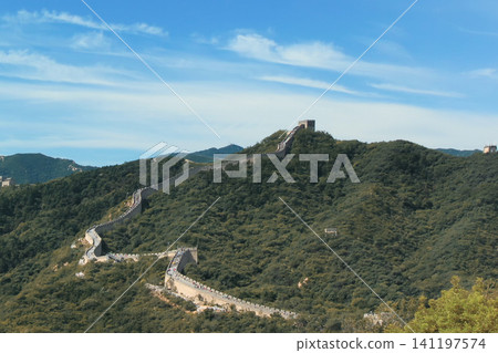 Panoramic view of the Great Wall of China winding through green mountains under a blue sky in Beijing. Panoramic view of the Great Wall of China winding through green mountains under a blue sky in Beijing. 141197574