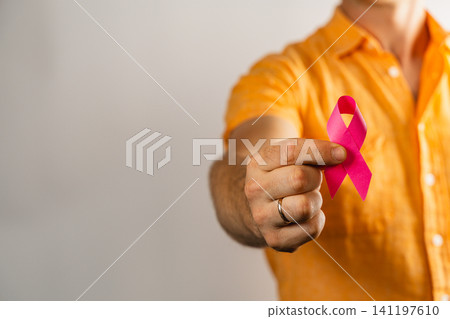 Man holding pink ribbon to show support for health awareness campaign Man holding pink ribbon to show support for health awareness campaign 141197610