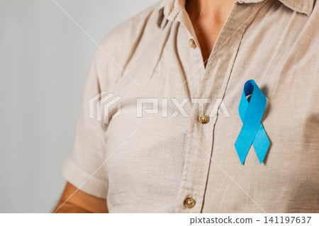 Support for health awareness shown through a blue ribbon on a man's shirt Support for health awareness shown through a blue ribbon on a man's shirt 141197637