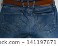 Denim jeans with pockets and belt detail against a simple background 141197671