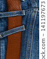 Closeup of denim jeans with pockets and a brown belt on a casual outfit 141197673
