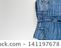 Casual blue denim jeans with pockets and zipper detail on plain background 141197678