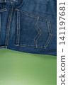 Closeup of blue denim jeans with pocket detail on green background 141197681