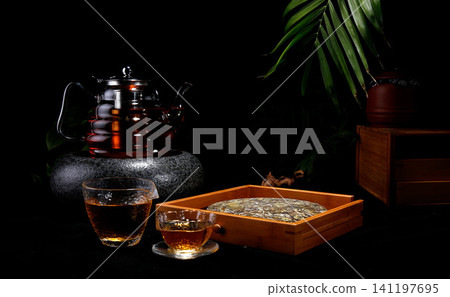 Traditional Chinese tea ceremony with pu erh tea cake and glass teapot Traditional Chinese tea ceremony with pu erh tea cake and glass teapot 141197695