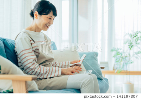 一位中年婦女正在查看她的銀行存摺。 141197807
