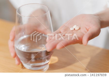 Hands of women taking medicine Hands of women taking medicine 141197839