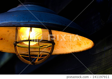 A scene with slightly aged streetlights illuminating the night road. A scene with slightly aged streetlights illuminating the night road. 141197911