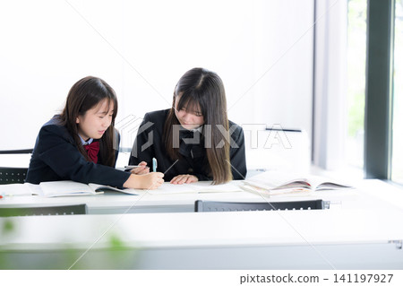 Japanese middle and high school girls studying together in the classroom, teaching each other: School life and exam/test preparation through cooperation. Japanese middle and high school girls studying together in the classroom, teaching each other: School life and exam/test preparation through cooperation. 141197927