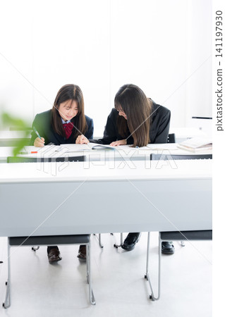 Japanese middle and high school girls studying together in the classroom, teaching each other: School life and exam/test preparation through cooperation. Japanese middle and high school girls studying together in the classroom, teaching each other: School life and exam/test preparation through cooperation. 141197930