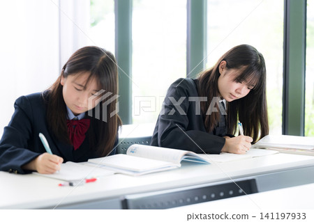 Japanese high school girls diligently studying in classrooms and cram schools; images of studying for high school entrance exams, university entrance exams, and regular tests. Japanese high school girls diligently studying in classrooms and cram schools; images of studying for high school entrance exams, university entrance exams, and regular tests. 141197933