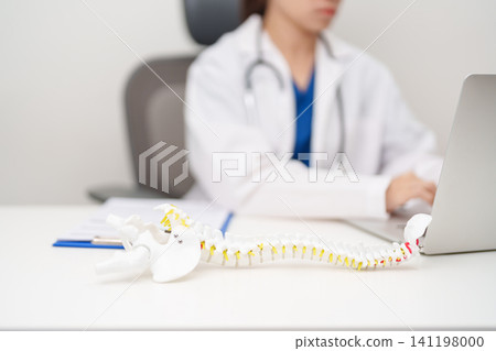 Doctor with human Spine anatomy model. Spinal Cord Disorder and disease, Back pain, Lumbar, Sacral pelvis, Cervical neck, Thoracic, Coccyx, Orthopedist, chiropractic, Office Syndrome and health Doctor with human Spine anatomy model. Spinal Cord Disorder and disease, Back pain, Lumbar, Sacral pelvis, Cervical neck, Thoracic, Coccyx, Orthopedist, chiropractic, Office Syndrome and health 141198000