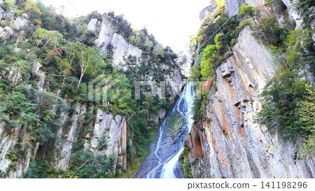 A spectacular view of the rugged columnar jointed cliffs of Sounkyo Gorge and the Ginga Falls. A spectacular view of the rugged columnar jointed cliffs of Sounkyo Gorge and the Ginga Falls. 141198296