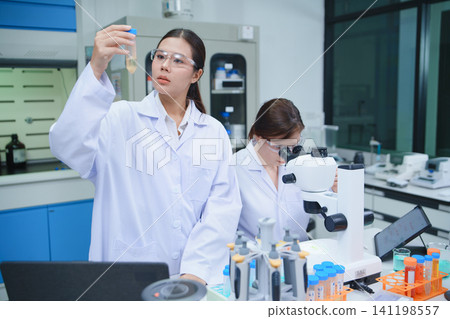 Scientist Analyzing Sample in Laboratory with Microscope Scientist Analyzing Sample in Laboratory with Microscope 141198557