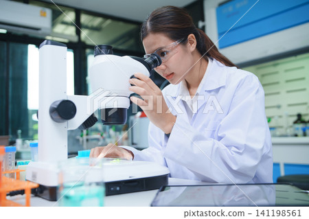 Scientist Conducting Chemical Research with Microscope in Laboratory 141198561