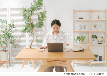 一位女士一臉擔憂地看著電腦 一位女士一臉擔憂地看著電腦 141198894