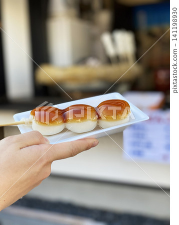 Mitarashi dango, a popular snack to eat while walking around. 141198930