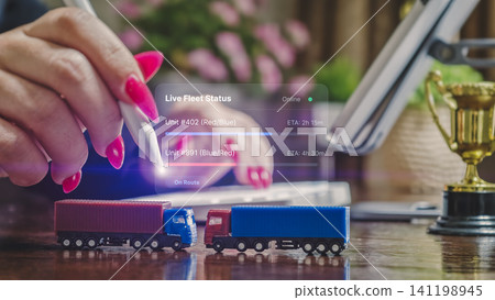 Smart logistics and live fleet tracking concept. Businesswoman managing cargo transport with futuristic digital interface and toy trucks. Smart logistics and live fleet tracking concept. Businesswoman managing cargo transport with futuristic digital interface and toy trucks. 141198945