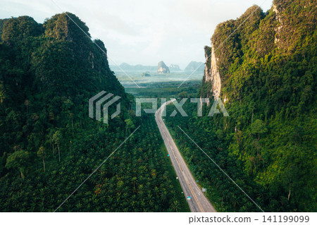 Aerial View of Scenic Green Road Cutting Through Limestone Mountains in Krabi Aerial View of Scenic Green Road Cutting Through Limestone Mountains in Krabi 141199099