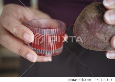 Holding beetroot and juice in hand for healthy drinks Holding beetroot and juice in hand for healthy drinks 141199123