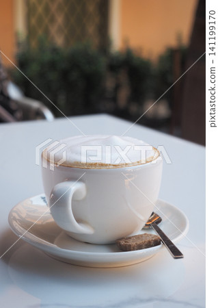 Coffee cup on a table at a cafe in the morning Coffee cup on a table at a cafe in the morning 141199170