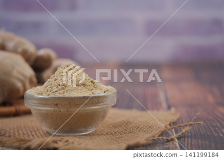 Ginger powder on a wooden table with fresh ginger nearby Ginger powder on a wooden table with fresh ginger nearby 141199184