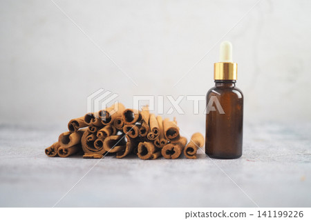 Cinnamon sticks and bottle on a gray surface Cinnamon sticks and bottle on a gray surface 141199226