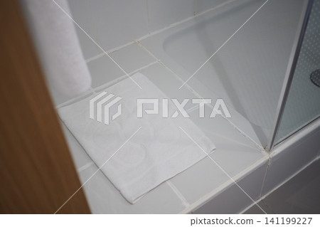 Wet towel on bathroom floor near shower area Wet towel on bathroom floor near shower area 141199227