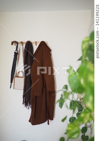 Coat and accessories hanging on a wall in a room Coat and accessories hanging on a wall in a room 141199228