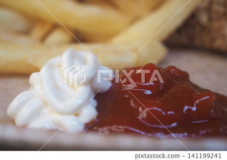 Ketchup and mayonnaise served with fries on a plate 141199241