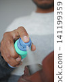 Hand applying spray in a shoe to remove odor  141199359