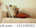 Colorful pillows arranged on a light couch in a cozy room 141199361
