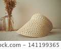 Stylish straw visor resting on a table next to dried flowers 141199365