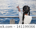 Child enjoying nature by the waterfront on a sunny day 141199366