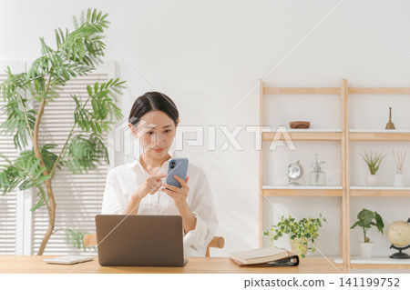 一位女士一臉擔憂地看著電腦 一位女士一臉擔憂地看著電腦 141199752