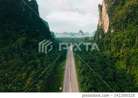 Aerial View of Scenic Green Road Cutting Through Limestone Mountains in Krabi Aerial View of Scenic Green Road Cutting Through Limestone Mountains in Krabi 141200328