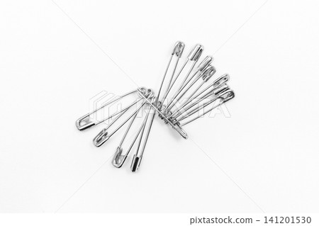 Pins or paper clips to remind you of objects on a white background Pins or paper clips to remind you of objects on a white background 141201530