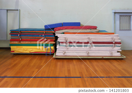 Gymnastics mats piled up against the wall of the gymnasium Gymnastics mats piled up against the wall of the gymnasium 141201803