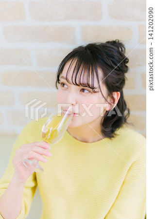 A young woman drinking champagne A young woman drinking champagne 141202090