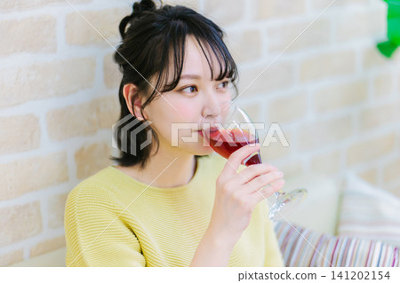 一位年輕女子在家喝紅酒 一位年輕女子在家喝紅酒 141202154