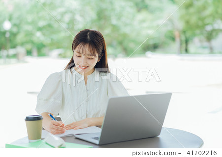 A young woman using her laptop on the terrace A young woman using her laptop on the terrace 141202216