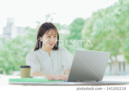 A young woman using her laptop on the terrace A young woman using her laptop on the terrace 141202218