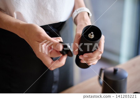 Woman preparing manual coffee grinder Woman preparing manual coffee grinder 141203221