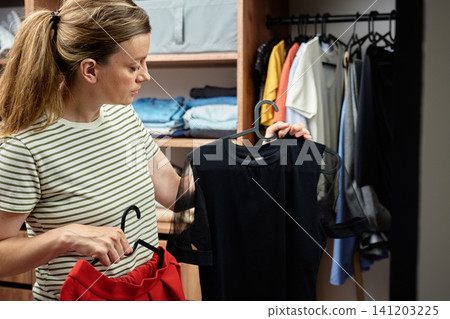 Woman choosing clothes for office work in wardrobe 141203225
