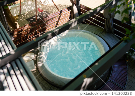 Bubbling Inflatable Spa in Shaded Outdoor Patio Area Bubbling Inflatable Spa in Shaded Outdoor Patio Area 141203228