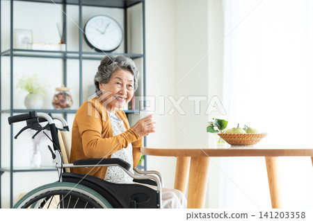 一位坐在輪椅上的老婦人在家中放鬆休息。 一位坐在輪椅上的老婦人在家中放鬆休息。 141203358
