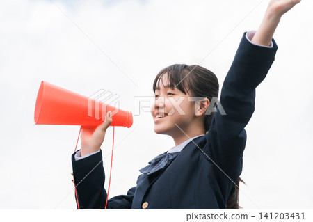 High school and junior high school girls in blazers cheering with megaphones High school and junior high school girls in blazers cheering with megaphones 141203431