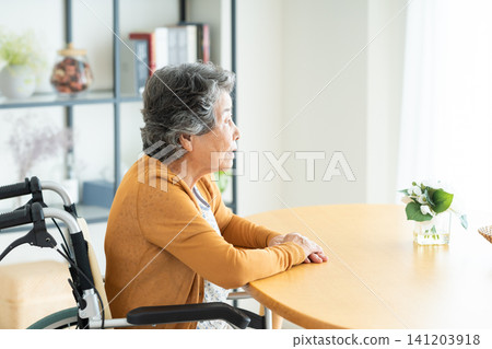 一位坐在輪椅上的老婦人在家中行動不便 一位坐在輪椅上的老婦人在家中行動不便 141203918