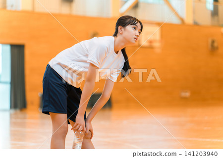 小學、國中和高中女生穿著運動服,在體育館裡努力訓練,疲憊不堪 小學、國中和高中女生穿著運動服,在體育館裡努力訓練,疲憊不堪 141203940