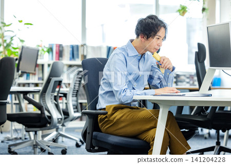 Businessmen eating calorie bars in the office 141204228