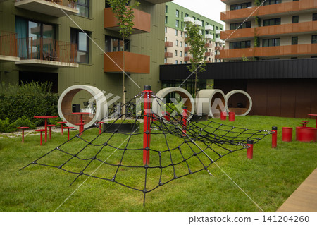Modern children playground with rope climbing net in residential courtyard Modern children playground with rope climbing net in residential courtyard 141204260